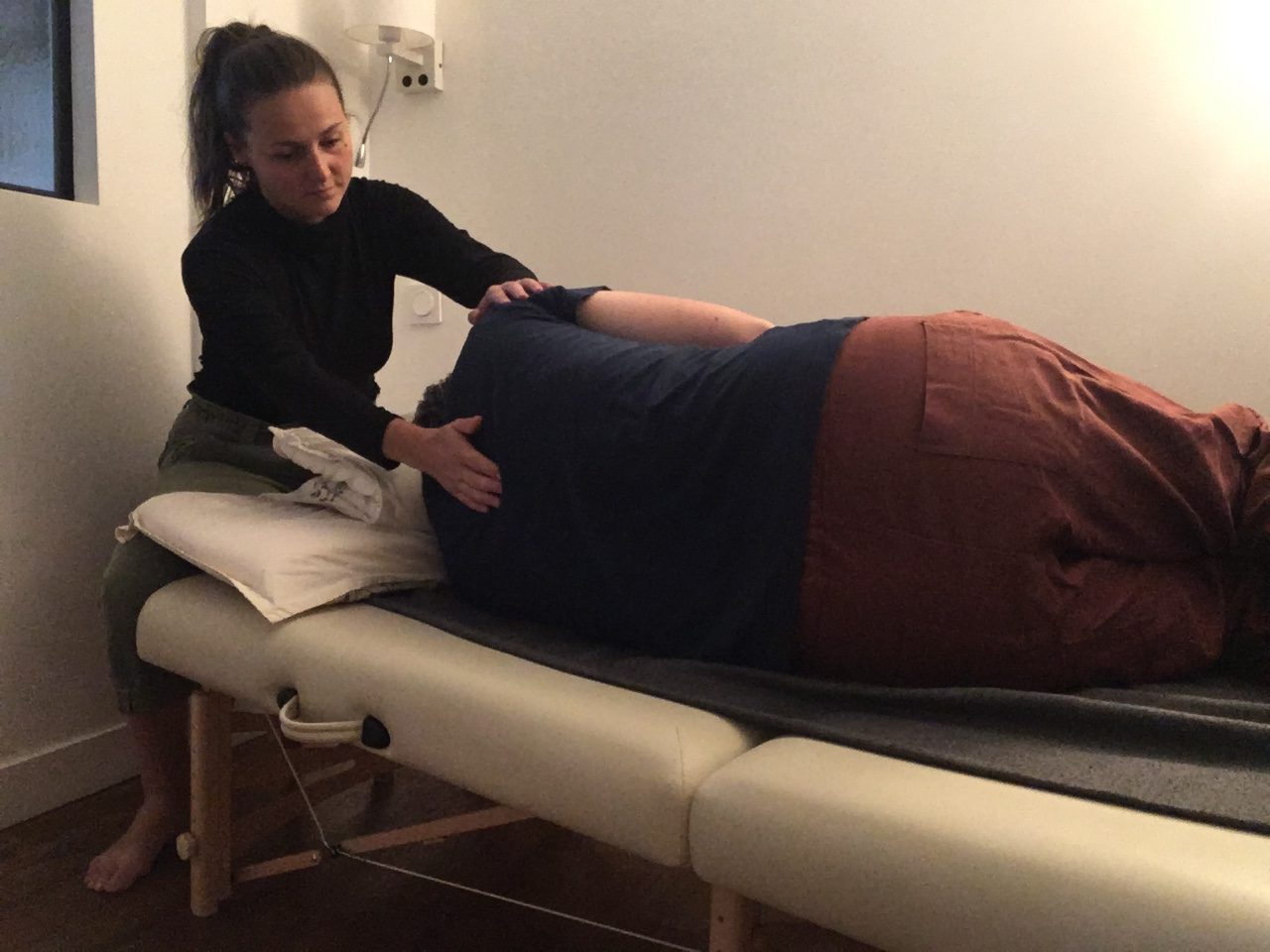 Séance individuelle d'Intégration fonctionnelle : les mains de Blanche accompagnent le dos d'une personne allongée